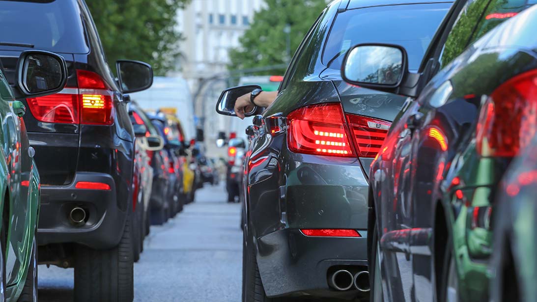 Autos stehen auf einer Straße im Stau. Blick auf die Rücklichter von zwei BMWs. 