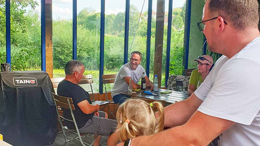 Eine Gruppe Menschen sitzt am Tisch.