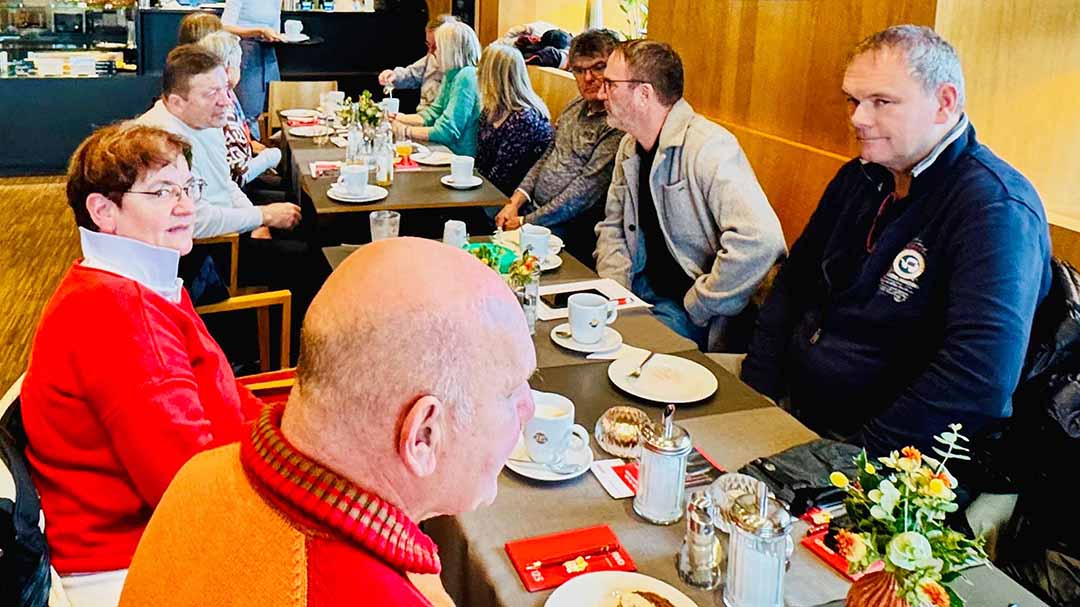 Menschen sitzen am Tisch und reden.