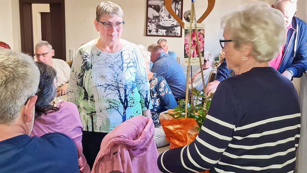 Das langjährige Mitglied Hannelore Jasky (rechts) überreicht der scheidenden Vorsitzenden Helga Kläs (Mitte) einen Rosenstock als Dank.